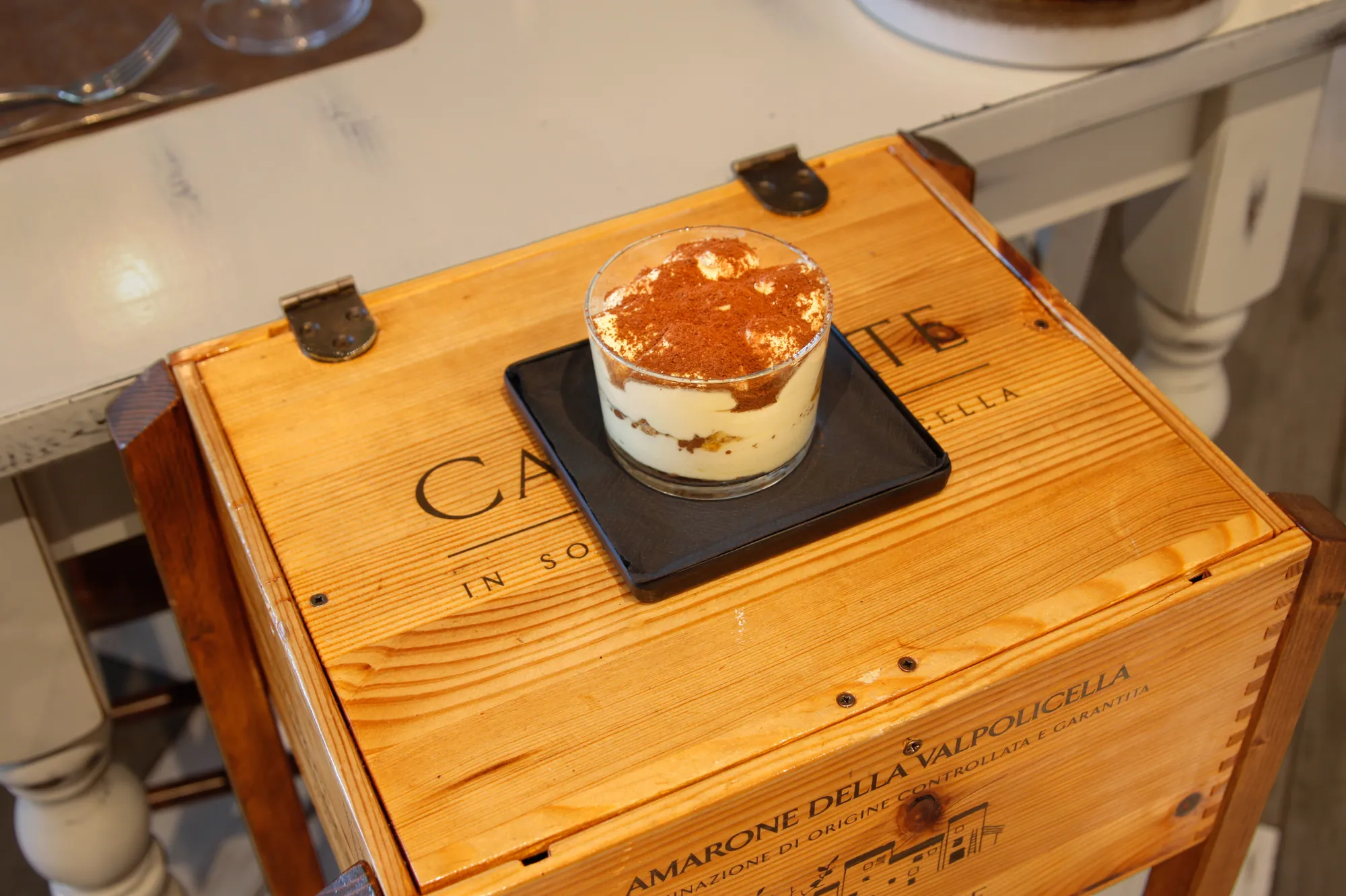 Tiramisù della casa in bicchiere, spolverato di cacao, con cantucci toscani